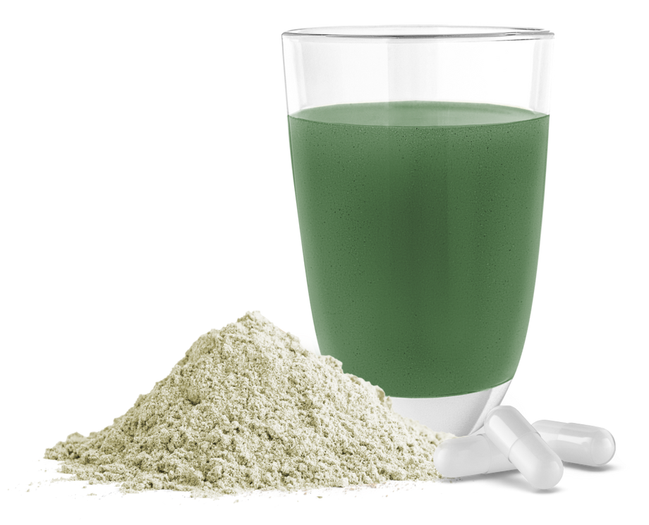 Produktbild – Ein Glas mit grünem Smoothie, daneben ein Häufchen Pulver und zwei weiße Kapseln.
