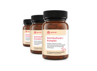 Produktbild – Drei Flaschen eines Nahrungsergänzungsmittels mit der Bezeichnung "Darmkulturen-Komplex". Auf den Etiketten ist "apriwell" und eine Beschreibung zur Unterstützung der Darmgesundheit mit Bakterienkulturen und Biotin zu lesen.