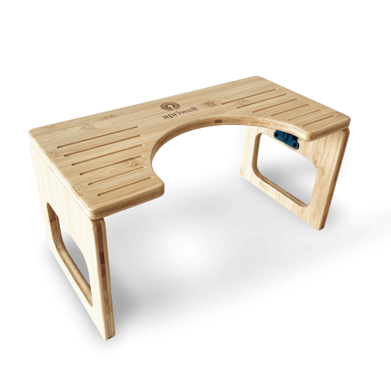 Produktbild - Ein Toilettenhocker aus hellem Bambusholz mit einer U-förmigen Aussparung auf der Oberseite. Auf der Oberfläche ist das Logo und der Schriftzug apriwell zu sehen.